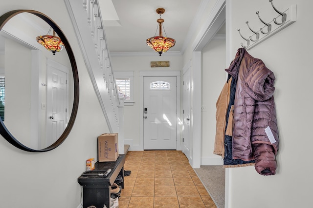 foyer entrance featuring light carpet, light tile patterned flooring, baseboards, and ornamental molding