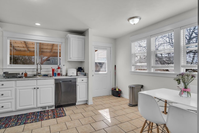 kitchen with a sink, white cabinetry, light countertops, light tile patterned floors, and dishwashing machine