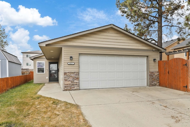 view of front of property with a gate, fence, stone siding, and an attached garage