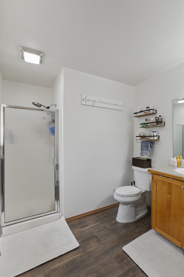 full bath with vanity, wood finished floors, visible vents, a shower stall, and toilet