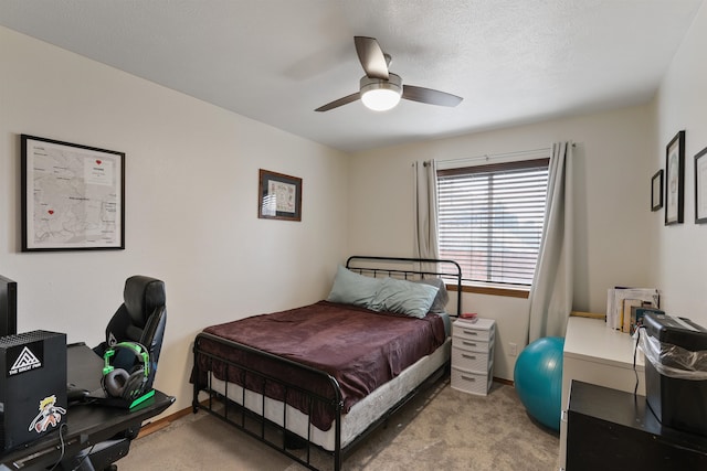 carpeted bedroom featuring a textured ceiling, baseboards, and ceiling fan