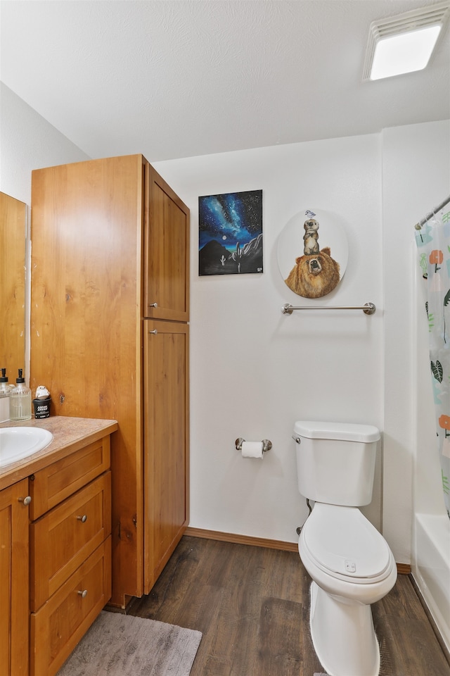 bathroom featuring baseboards, toilet, wood finished floors, vanity, and shower / bathtub combination with curtain