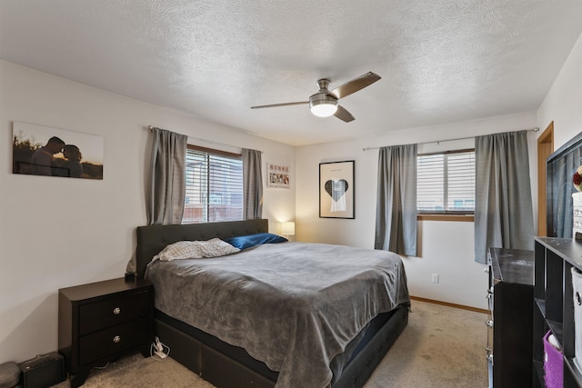 bedroom with baseboards, light carpet, a textured ceiling, and ceiling fan