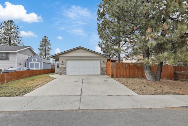 view of front of property featuring a garage, stone siding, concrete driveway, and fence