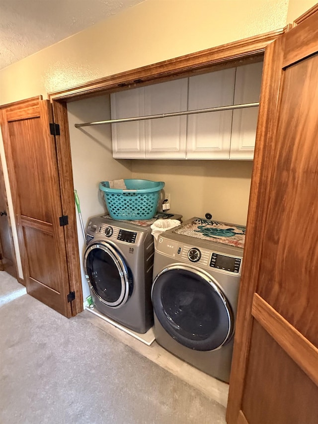 washroom featuring washing machine and clothes dryer and a textured wall