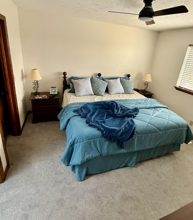 bedroom with carpet, a ceiling fan, and a textured ceiling