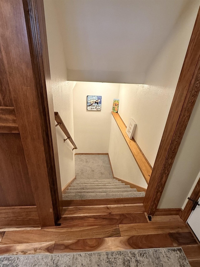 stairway featuring baseboards and carpet floors