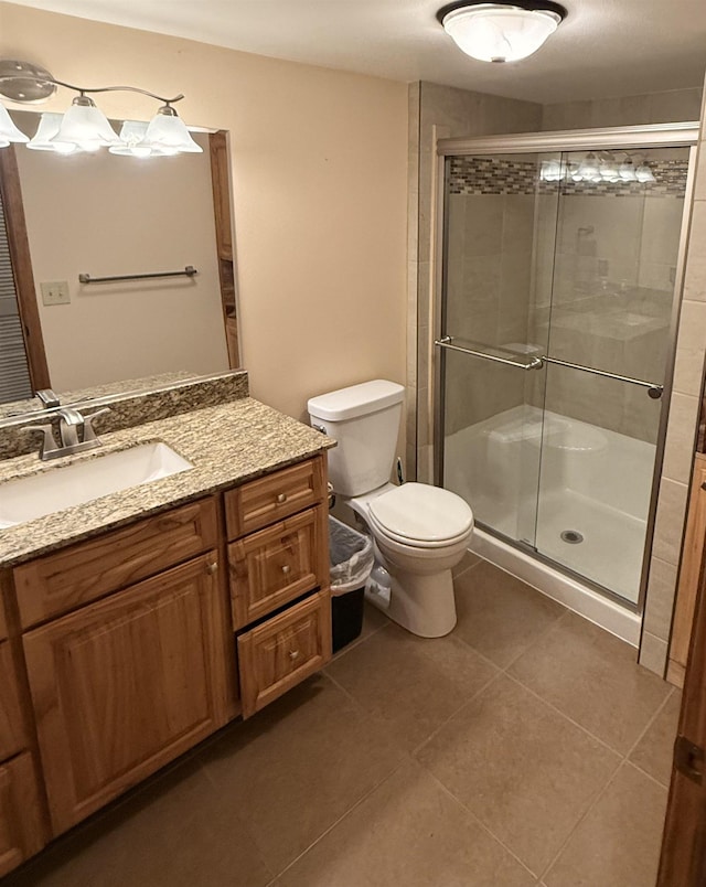 bathroom with toilet, a stall shower, vanity, and tile patterned flooring