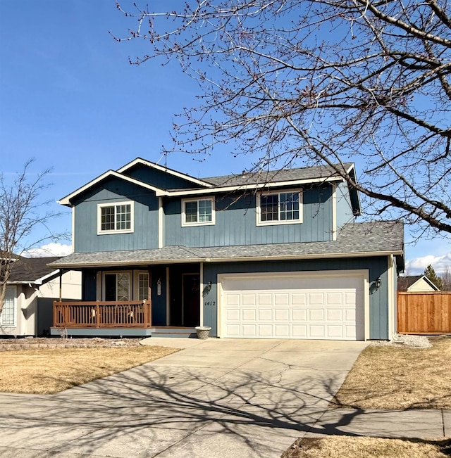 traditional-style home with fence, driveway, covered porch, a shingled roof, and a garage