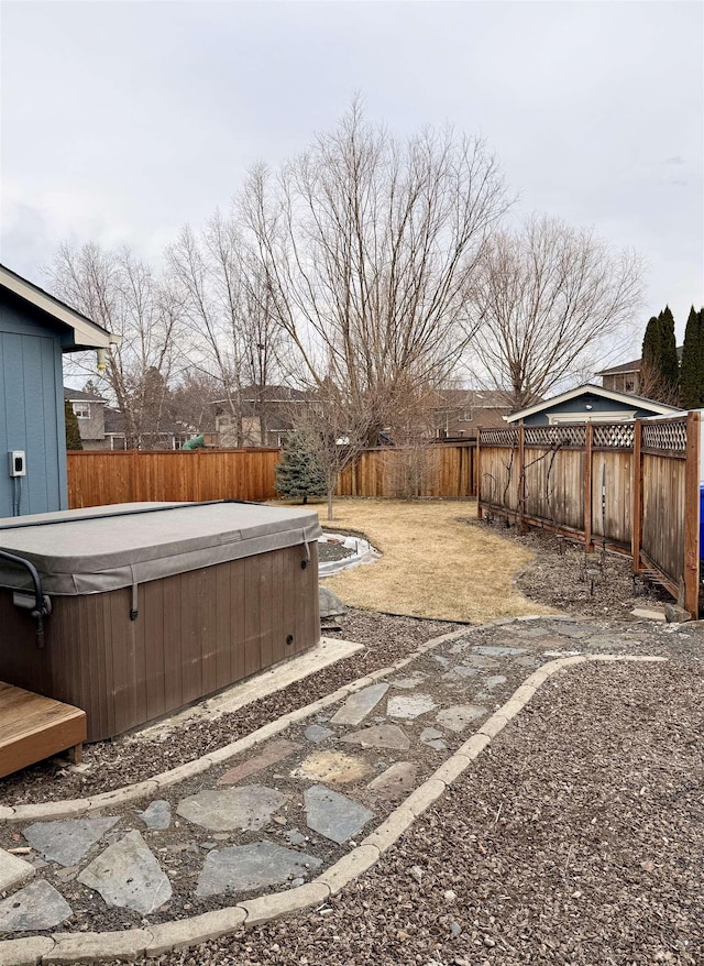 view of yard with a hot tub and a fenced backyard