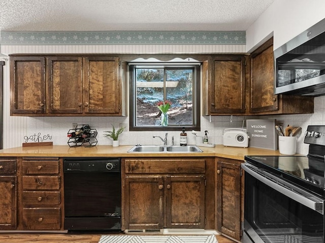 kitchen featuring dark brown cabinets, appliances with stainless steel finishes, light countertops, and a sink