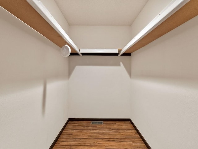 walk in closet featuring visible vents and wood finished floors