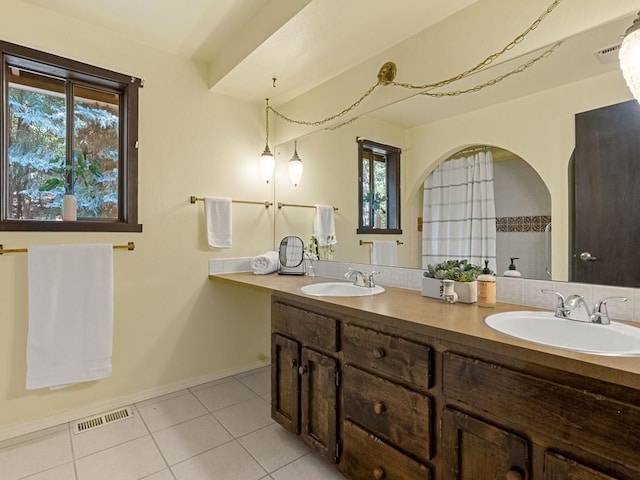 full bath featuring tile patterned floors, visible vents, double vanity, and a sink