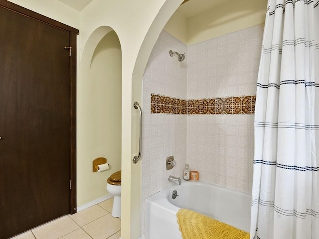 bathroom with tile patterned flooring, shower / bath combination with curtain, and toilet