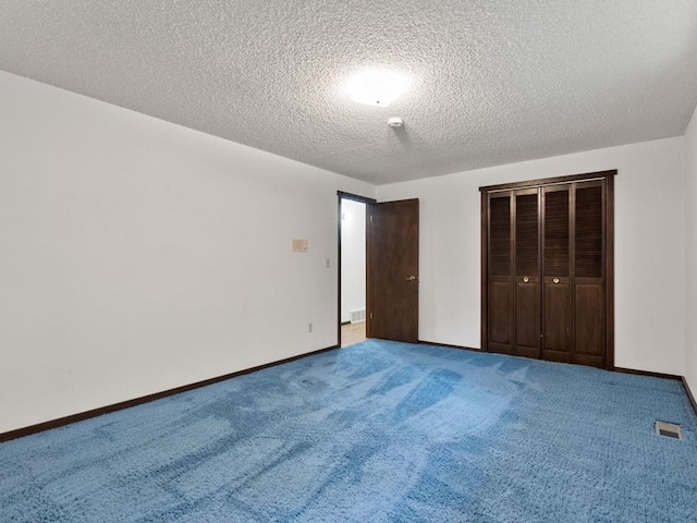 unfurnished bedroom featuring carpet flooring, baseboards, visible vents, and a closet