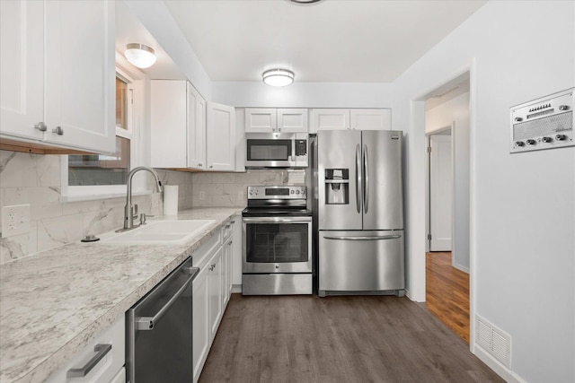 kitchen with a sink, tasteful backsplash, white cabinetry, appliances with stainless steel finishes, and light countertops