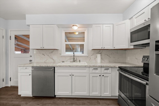 kitchen with white cabinetry, tasteful backsplash, appliances with stainless steel finishes, and a sink