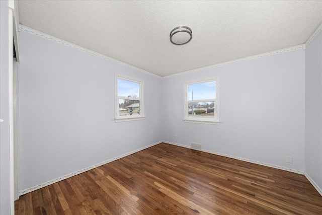 spare room with visible vents, crown molding, baseboards, wood finished floors, and a textured ceiling