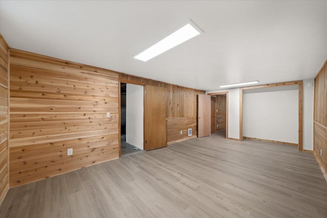 interior space with wooden walls and light wood-style flooring