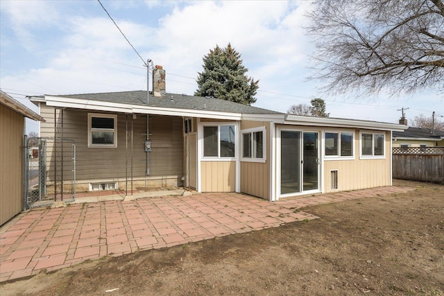 rear view of property with a patio area, a chimney, and fence