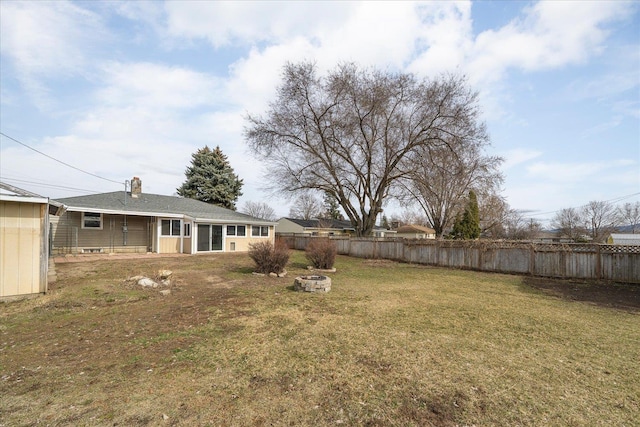 view of yard with fence and an outdoor fire pit