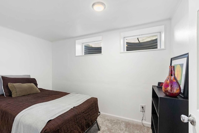 bedroom with baseboards and light carpet