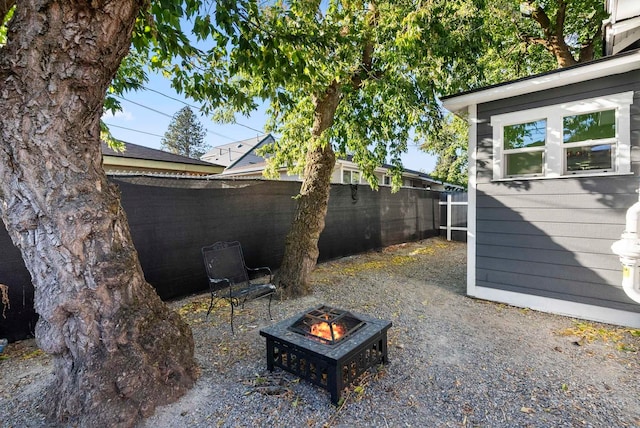 exterior space featuring an outdoor fire pit and fence