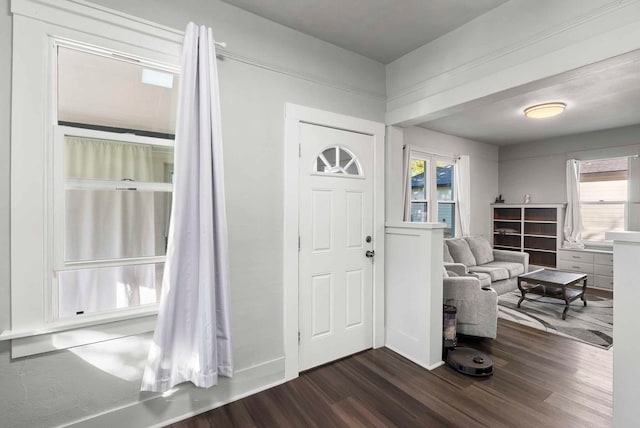 foyer with dark wood finished floors and baseboards