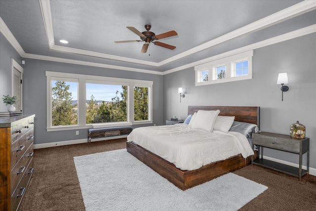 bedroom featuring multiple windows, baseboards, a tray ceiling, and ornamental molding