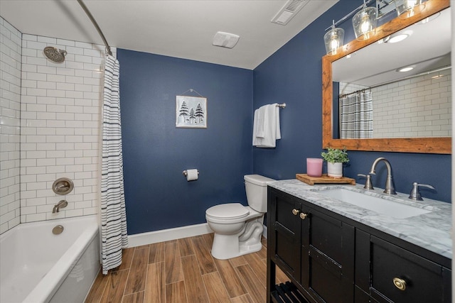 bathroom featuring vanity, baseboards, wood tiled floor, shower / bath combo with shower curtain, and toilet