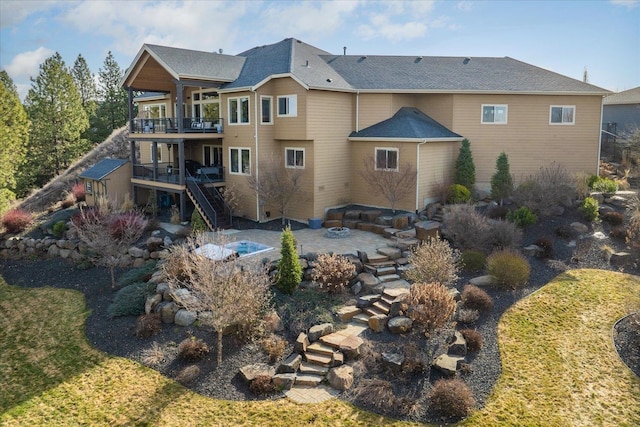 back of property featuring stairway, a wooden deck, and a patio area