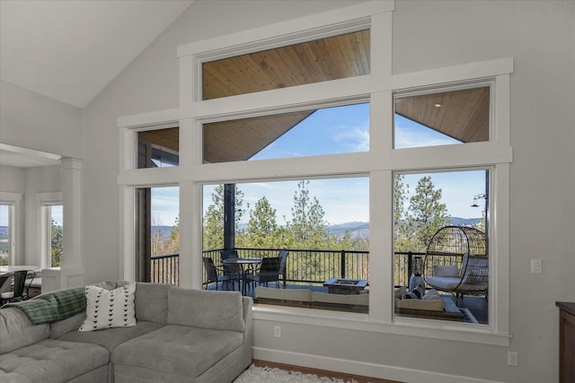 living room with a mountain view, high vaulted ceiling, and decorative columns