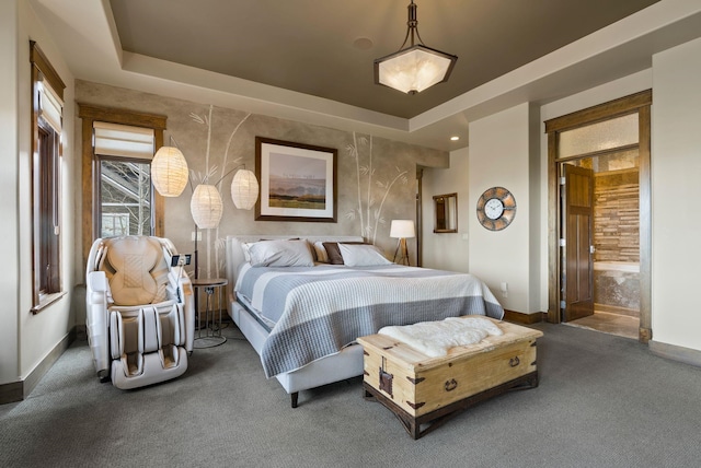 carpeted bedroom with a raised ceiling and baseboards