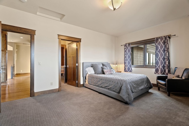 carpeted bedroom featuring baseboards and attic access