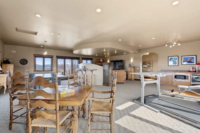 dining room featuring wine cooler, recessed lighting, light colored carpet, and arched walkways