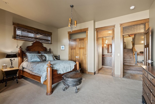 bedroom featuring light colored carpet, ensuite bathroom, and baseboards