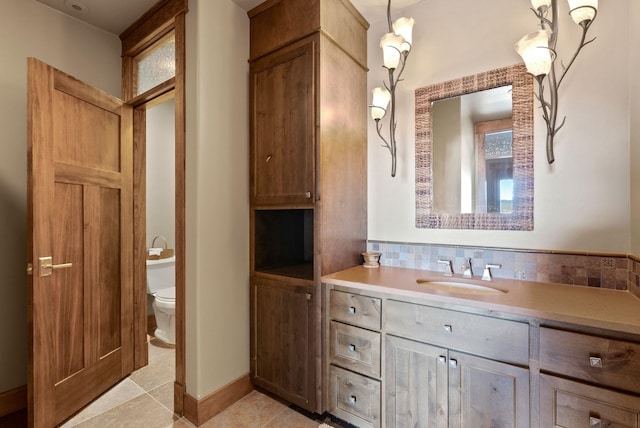 full bathroom with tile patterned floors, toilet, tasteful backsplash, baseboards, and vanity