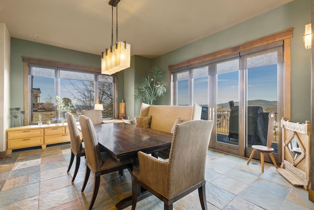 dining area with a wealth of natural light and stone tile floors