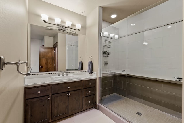 bathroom featuring tile patterned flooring, a stall shower, and vanity