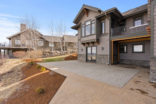 rear view of property featuring a patio, french doors, and a chimney