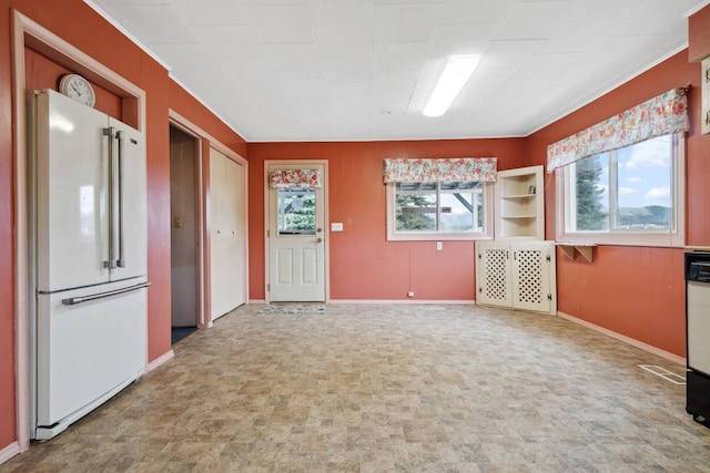 empty room with baseboards and crown molding