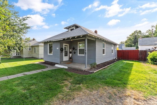 bungalow-style house featuring a fenced backyard, a front yard, and a patio area