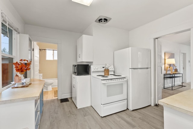 kitchen with white appliances, light wood-style floors, light countertops, and white cabinetry