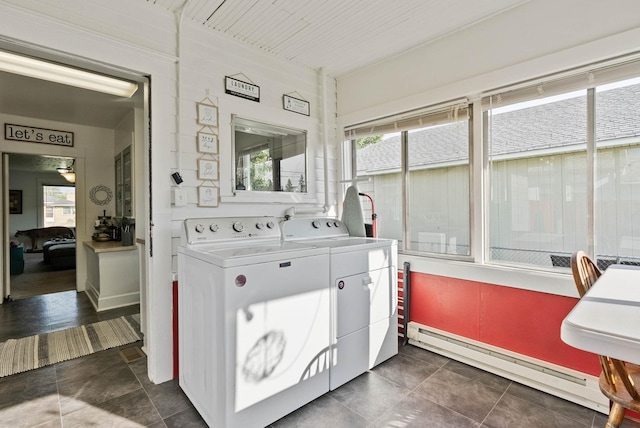 laundry room with washing machine and clothes dryer, laundry area, a healthy amount of sunlight, and a baseboard radiator