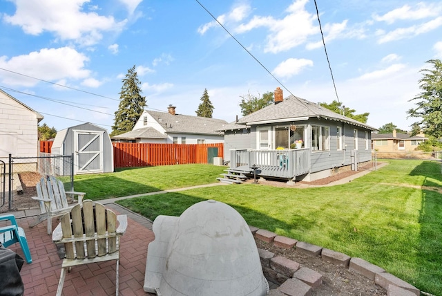 back of house featuring a patio, an outbuilding, a fenced backyard, a storage unit, and a deck