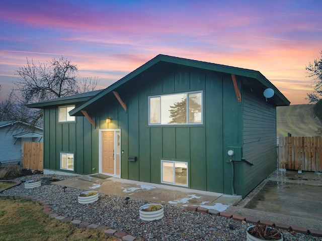 exterior space featuring a patio area, fence, and board and batten siding