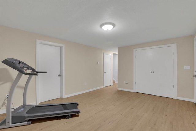 exercise room featuring baseboards and wood finished floors