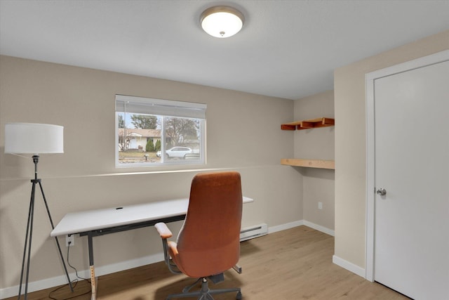 office area with built in desk, baseboards, and wood finished floors