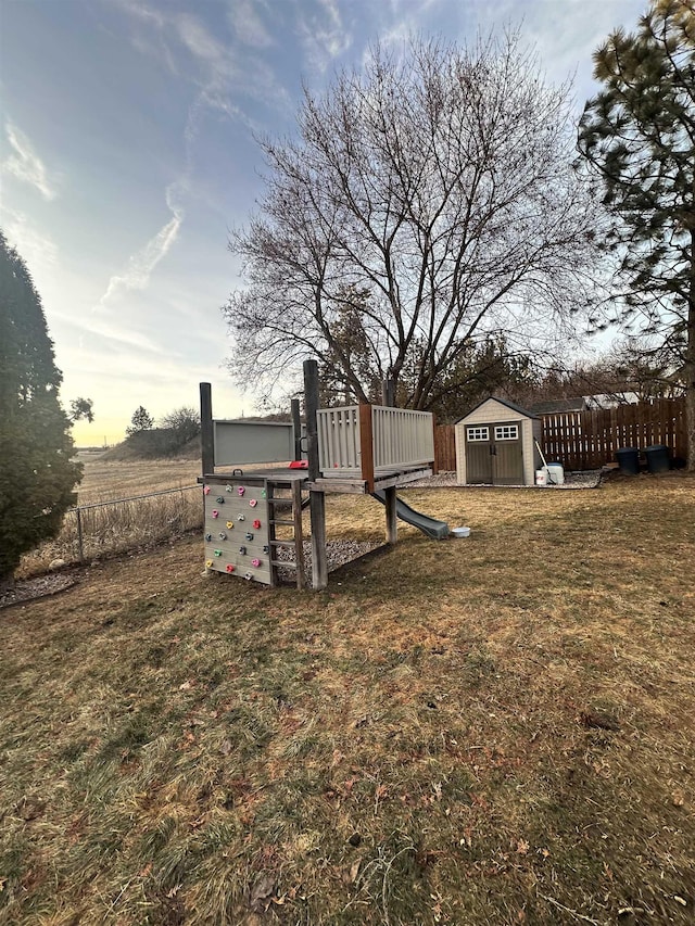 view of yard with a storage unit, an outdoor structure, and fence