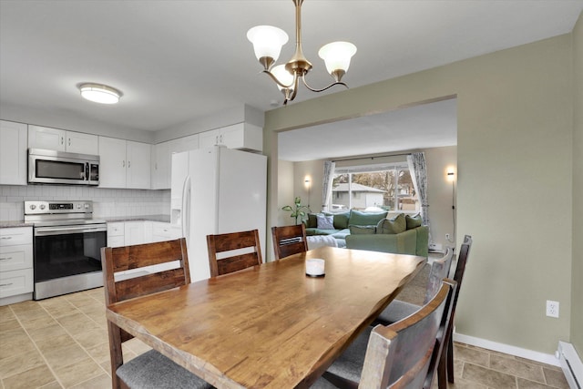 dining space featuring a chandelier, baseboards, and a baseboard radiator